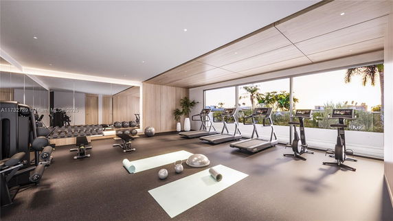 Interior view of a modern gym with exercise equipment and large mirrors.