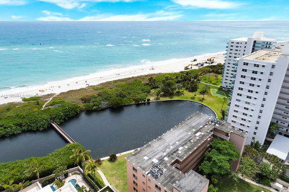Panoramic view of a beachfront area with high-rise buildings and a pathway leading to the ocean.