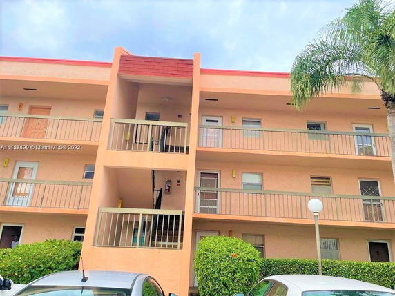 Front view of a multi-story apartment building with balconies.