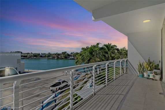 Balcony view overlooking water and distant residential area.