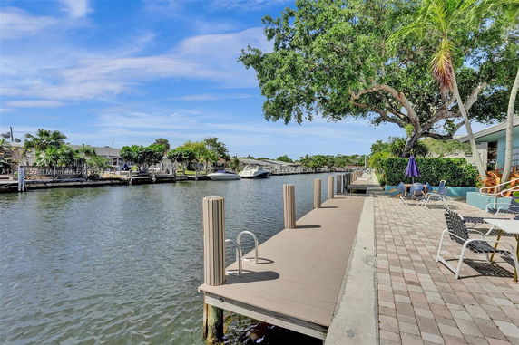 View of a waterfront area with boats docked along a canal and outdoor seating.