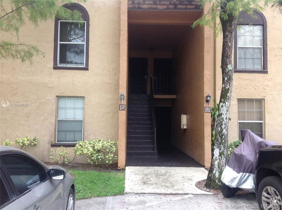 Front view of a multi-story residential building with exposed staircase.