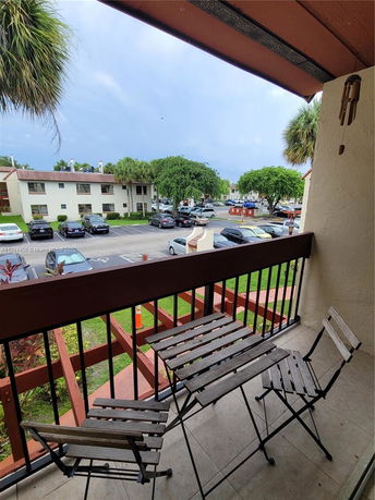 Balcony view overlooking a parking area and residential buildings.