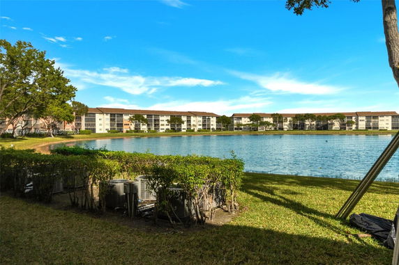 View of a lake with multiple apartment buildings in the background.