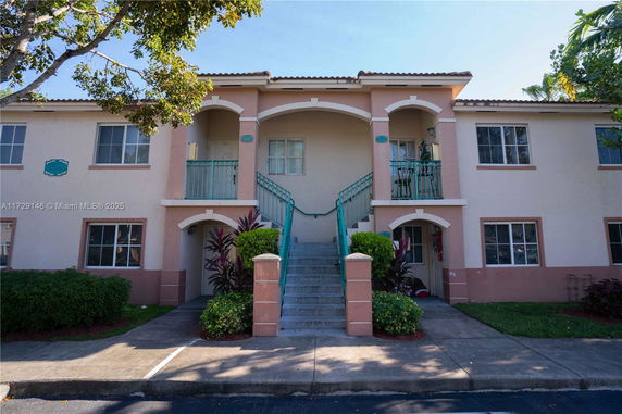 Front view of a two-story building with balconies and staircases.