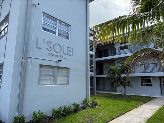 Front view of a multi-story apartment building with balconies and a security camera.