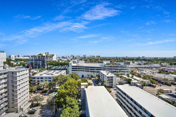 Panoramic view of a cityscape with multiple buildings and a distant ocean horizon.