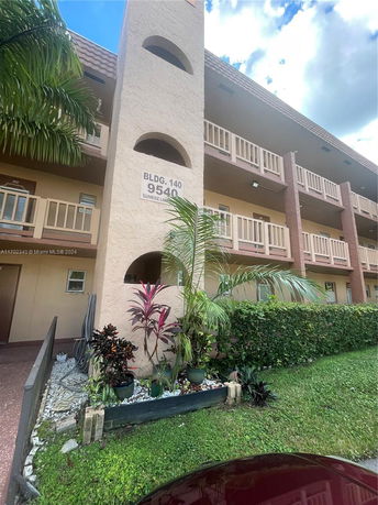 Front view of a multi-story residential building with balconies and a sign reading BLDG. 140, 9540, Sunrise Lakes.