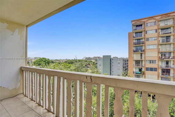View from a balcony overlooking other apartment buildings and greenery.