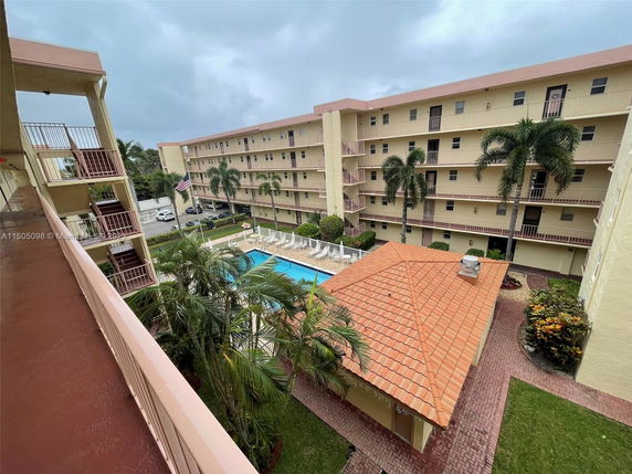 View of a multi-story residential building overlooking a courtyard with a swimming pool.