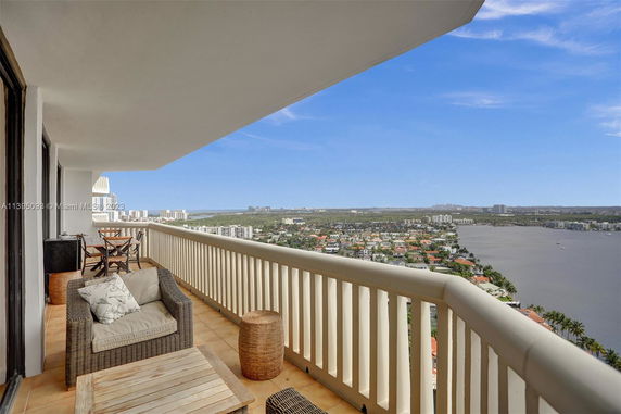 Balcony view overlooking a vast urban landscape and waterbody.