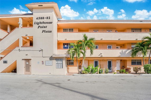 Front view of a multi-story building labeled Lighthouse Point Plaza.