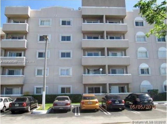 Front view of a multi-story apartment building with balconies.