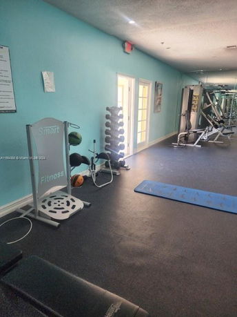 Indoor fitness area with exercise equipment and mats.