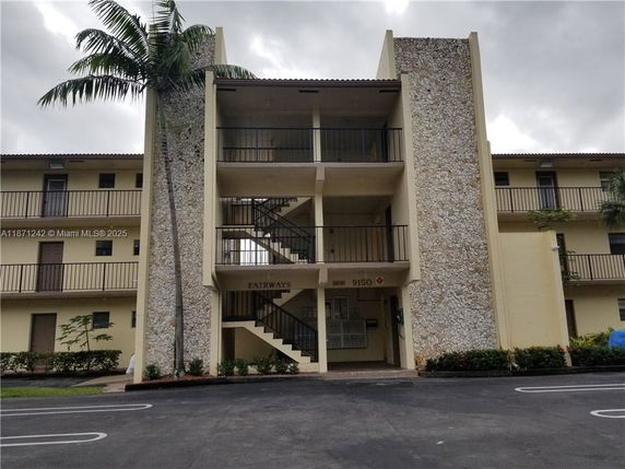Front view of a multi-story apartment building with balconies and stone accents.