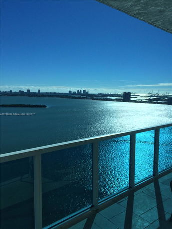 Panoramic view of a city skyline and water from a balcony.