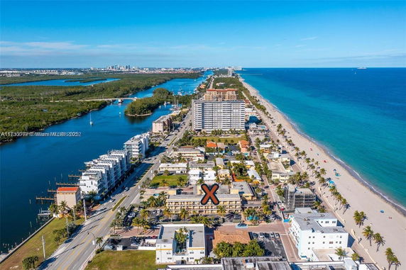 Panoramic view of beachfront cityscape with ocean and buildings.