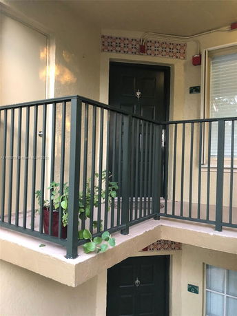 Front view of a building with a balcony and green door.