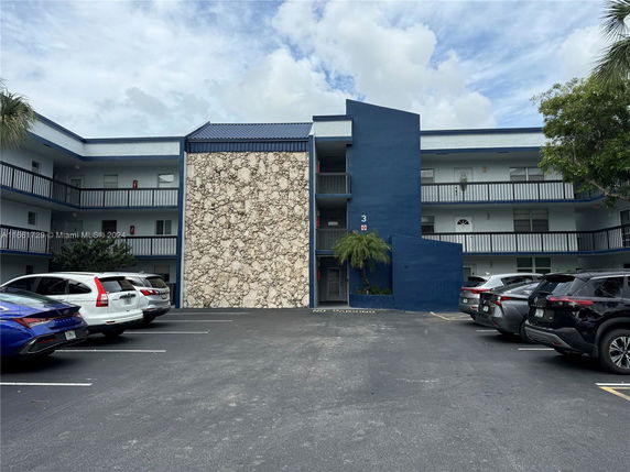 Front view of a three-story building with blue and stone facade elements.