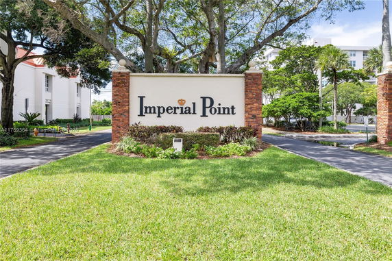 Entrance sign of a residential complex with surrounding greenery.