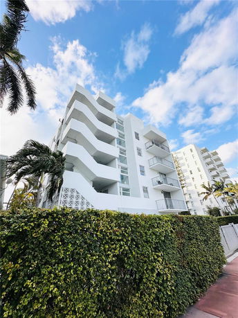 Front view of a multi-story apartment building with balconies.