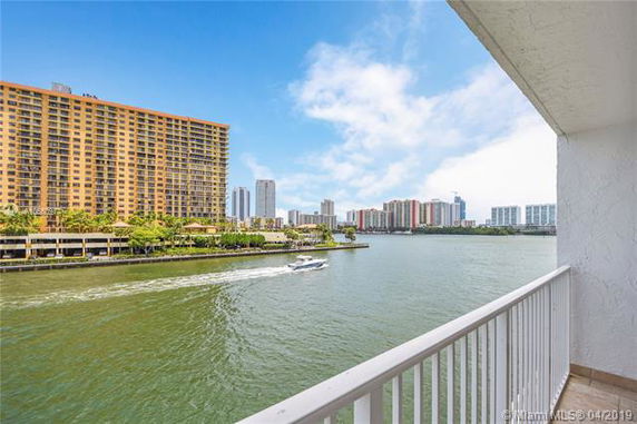 Panoramic view from a balcony showing a river and distant high-rise buildings.