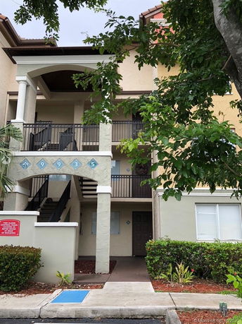 Front view of a multi-story residential building with external stairs.