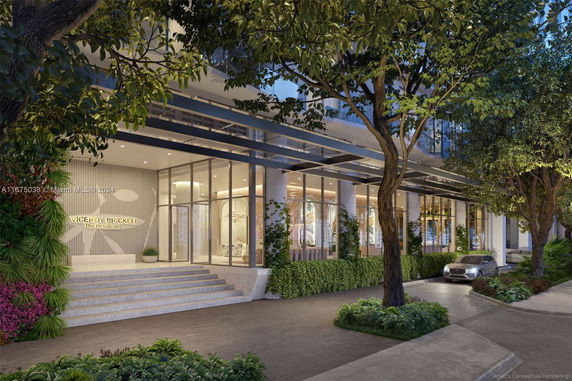 Front view of a modern building with glass facade and entrance stairs.