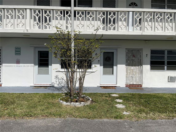 Front view of a two-story building with decorative railings.
