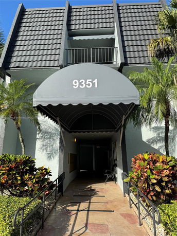 Entrance view of a building with a canopy and tiled roof.