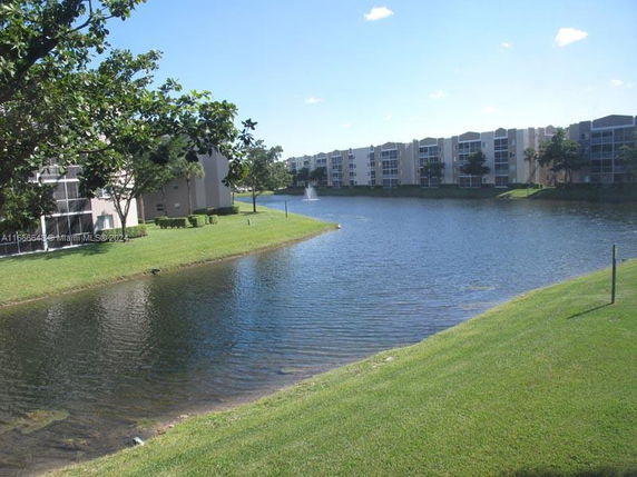 View of apartment buildings near a large pond with a fountain
