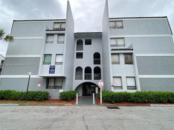 Front view of a multi-story residential building with a central entrance.