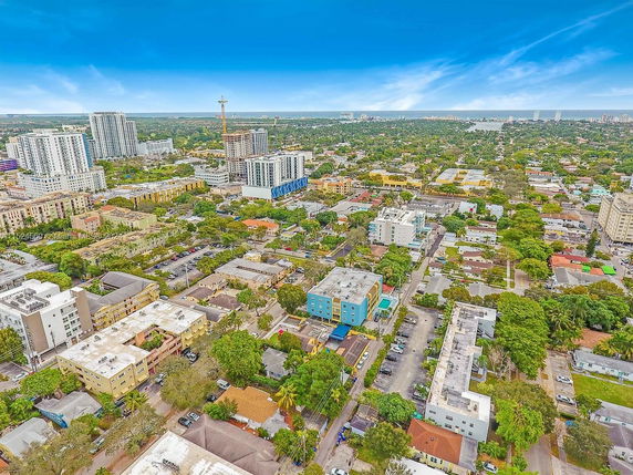 Aerial panoramic view of an urban area with multiple buildings and green spaces.
