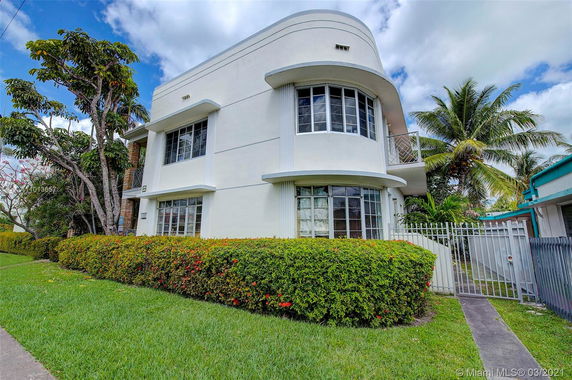 Front view of a multi-story house with large windows and a gated entrance.