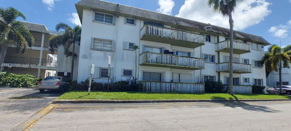 Front view of a three-story apartment building with balconies.