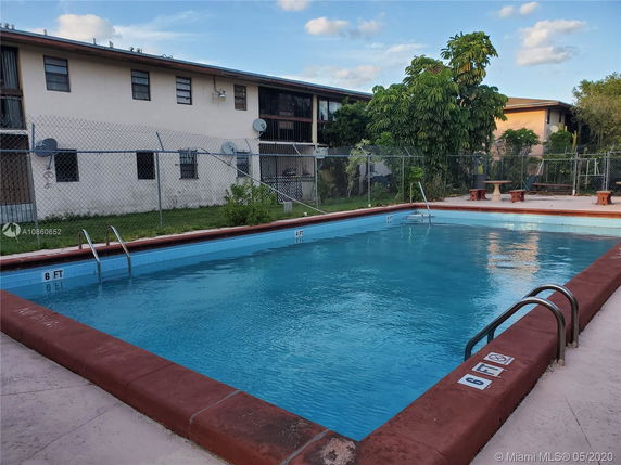 Outdoor swimming pool area in front of a building.