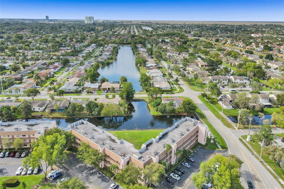 Aerial panoramic view of a residential area with houses surrounding a water body.