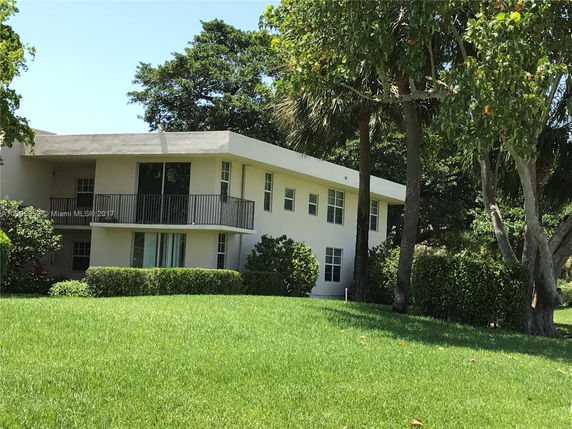 Front view of a two-story house with a flat roof and balcony.