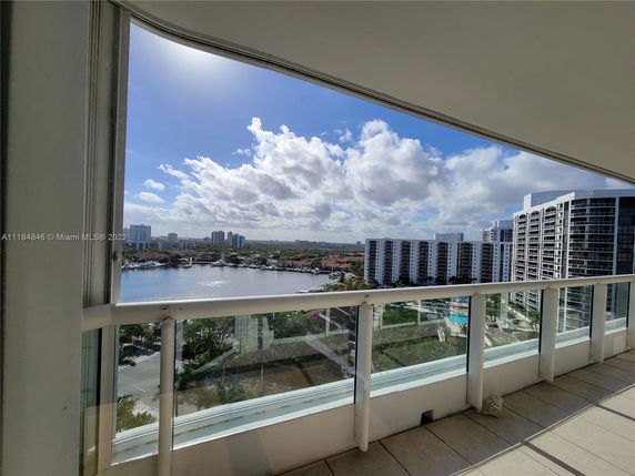 Panoramic view from a balcony overlooking a body of water and surrounding buildings.