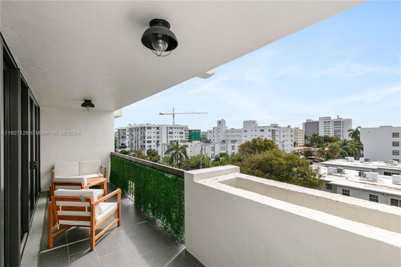 Balcony view of urban buildings and greenery.