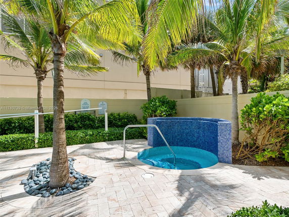 Outdoor swimming pool with surrounding palm trees.