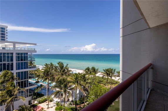 View of the ocean and beach from a building balcony.
