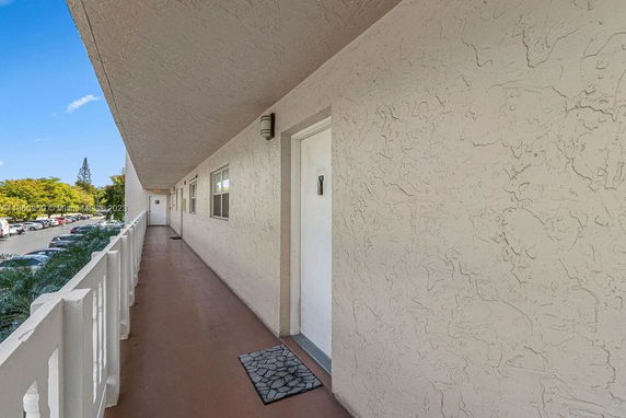 View of building corridor with a parking area visible to the side.