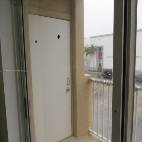 View from a balcony showing part of a building entrance and surrounding buildings.