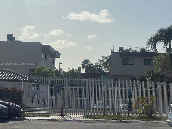 View of a gated area with two buildings in the background