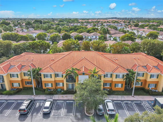 Aerial view of a neighborhood with rows of houses and red-tiled roofs.