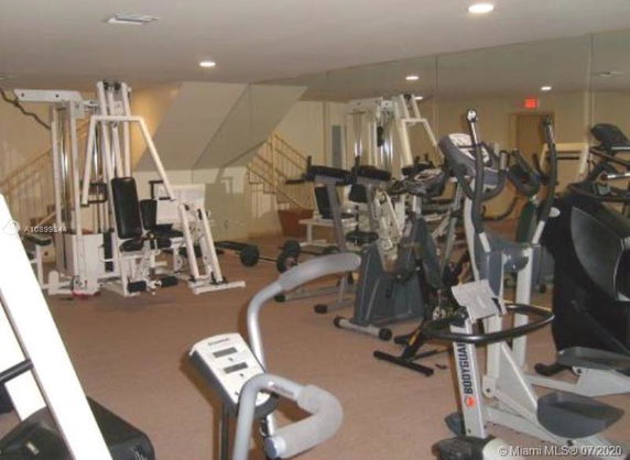 Indoor gym area with various exercise equipment, including treadmills and weight machines.