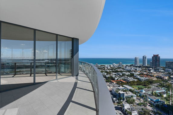 Panoramic view from a balcony overlooking cityscape and ocean.