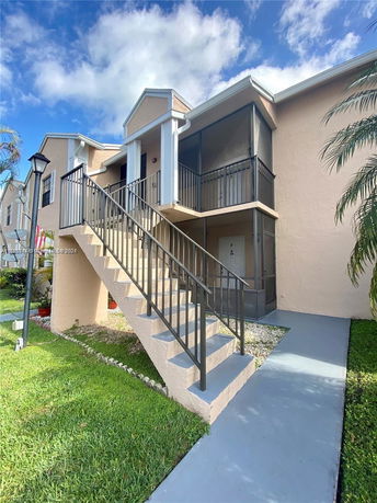 Front view of a multi-story building with an exterior staircase.