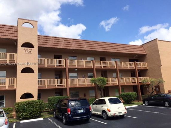 Front view of a three-story apartment building with a brown facade and balconies.